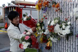 woman placing flowers at memorial