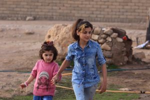 Yazidi girls Suhayla, 12, and Rosa, 13, who were reunited with their family after being enslaved by Islamic State militants, walk at Sharya Camp in Duhuk, Iraq December 18,