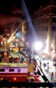 A crowd gathers as New York Fire Department personnel fight a fire in the Bronx borough of New York City, New York, in this still image taken from a December 28, 2017 social media video.