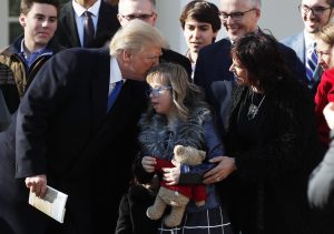 U.S. President Donald Trump greets a young girl among families gathered in the White House Rose Garden as he addresses the annual March for Life rally, taking place on the nearby National Mall in Washington, U.S., January 19, 2018.