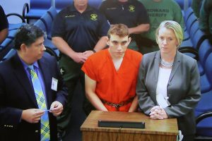 Nikolas Cruz (C) appears via video monitor with Melisa McNeill (R), his public defender, at a bond court hearing after being charged with 17 counts of premeditated murder, in Fort Lauderdale, Florida, U.S., February 15, 2018. REUTERS/Susan Stocker/Pool