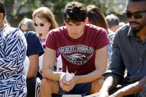 Daniel Journey (C), an 18-year-old senior at Marjory Stoneman Douglas High School in Parkland, attends a community prayer vigil for victims of yesterday's shooting at his school, at Parkridge Church in Pompano Beach, Florida, February 15, 2018. Journey said he lost two friends he had known and grown up with since they were seven years old in the shooting. REUTERS/Jonathan Drake