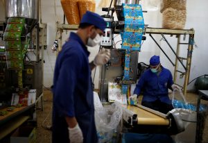 Palestinians work at Wael Al-Wadiya's snacks and chips factory, east of Gaza City February 19, 2018. REUTERS/Mohammed Salem