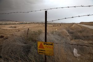 A sign warning from land mines is seen on a fence near Qasr Al-Yahud, a traditional baptism site along the Jordan River, near Jericho in the occupied West Bank, March 29, 2018