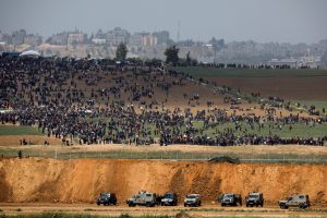Israeli military vehicles are seen next to the border on the Israeli side of the Israel-Gaza border, as Palestinians demonstrate on the Gaza side of the border, March 30, 2018. REUTERS/Amir Cohen