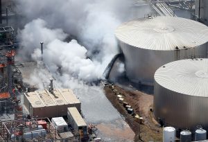 A black liquid pours from a ruptured tank following an explosion at Husky Energy oil refinery in Superior, Wisconsin. REUTERS/Robert King/Duluth News Tribune