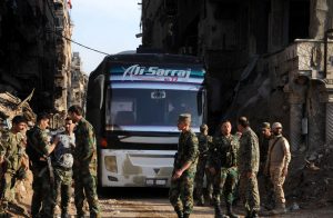 Soldiers loyal to Syria's President Bashar al Assad are seen near a bus carrying rebels from Yarmouk Palestinian camp in Damascus, Syria April 30, 2018. SANA/ via REUTERS