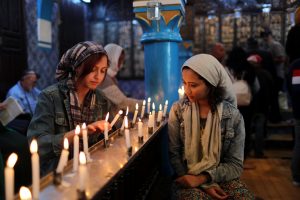 Cyrine Ben Said (L) and Amnia Ben Khalif, Muslim Tunisians, light candles during a religious ceremony at Ghriba, the oldest Jewish synagogue in Africa, during an annual pilgrimage in Djerba, Tunisia May 2, 2018. Picture taken May 2, 2018. REUTERS/Ahmed Jadallah