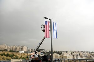 FILE PHOTO: A worker on a crane hangs a U.S. flag next to an Israeli flag, next to the entrance to the U.S. consulate in Jerusalem, May 7, 2018. REUTERS/Ronen Zvulun/File Photo