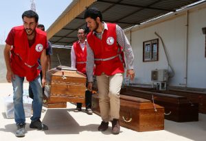 Libyan Red Crescent workers carry coffins, containing the remains of the bodies of Egyptian Copts killed by Islamic State in Sirte, which are to be transferred to Egypt after the forensic tests were completed and the bodies identified, at a morgue in Misrata, Libya May 14, 2018. REUTERS/Ismail Zitouny