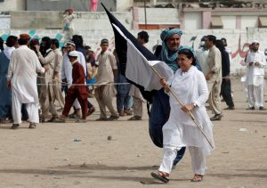 Ismat Shahjahan, organiser of the Pashtun Tahaffuz Movement (PTM) walks with flags at rally against, what they say, are human rights violations by security forces, in Karachi, Pakistan May 13, 2018. Picture taken May 13, 2018. REUTERS/Akhtar Soomro
