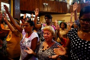 People react during a religious ceremony where victims of the Boeing 737 plane crash were remembered at a church in Havana, Cuba, May 20, 2018. REUTERS/Alexandre Meneghini