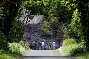 Journalists and Hawaii National Guard soldiers document a lava flow on Highway 137 southeast of Pahoa during ongoing eruptions of the Kilauea Volcano in Hawaii, U.S., May 20, 2018. REUTERS/Terray Sylvester