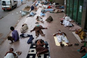 Residents sleep on a building pavement, to escape heat and frequent power outage in their residence area Karachi, Pakistan. REUTERS/Akhtar Soomro