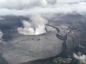 An aerial view of Kilauea Volcano's summit caldera and an ash plume billowing from Halema'uma'u, a crater within the caldera, May 27, 2018. Courtesy of the Civil Air Patrol/USGS/Handout via REUTERS