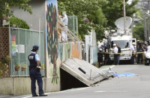 A police officer stands guard at the site where a girl was killed by fallen wall caused by an earthquake at an elementary school in Takatsuki, Osaka prefecture, western Japan, in this photo taken by Kyodo June 18, 2018. Mandatory credit Kyodo/via REUTERS ATTENTION EDITORS - THIS IMAGE WAS PROVIDED BY A THIRD PARTY. MANDATORY CREDIT. JAPAN OUT. NO COMMERCIAL OR EDITORIAL SALES IN JAPAN.
