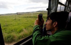 A tourist from Tokyo's university, takes photos from a bus at an area devastated by the March 11, 2011 earthquake and tsunami, near Tokyo Electric Power Co's (TEPCO) tsunami-crippled Fukushima Daiichi nuclear power plant, in Namie town, Fukushima prefecture, Japan May 19, 2018. Picture taken May 19, 2018. REUTERS/Toru Hanai