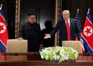 FILE PHOTO: U.S. President Donald Trump and North Korea's leader Kim Jong Un (L) arrive to sign a document to acknowledge the progress of the talks and pledge to keep momentum going, after their summit at the Capella Hotel on Sentosa island in Singapore, June 12, 2018. REUTERS/Jonathan Ernst/File Photo