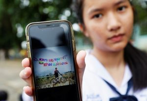 A student shows a photo of her classmate Prachak Sutham, 13, who is a member of an under-16 soccer team that went missing with their coach at a flooded cave, in Mae Sai Prasitsart school in the northern province of Chiang Rai, Thailand, July 2, 2018. REUTERS/Soe Zeya Tun