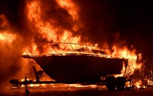 A boat burns as fast-moving wildfire that destroyed homes driven by strong wind and high temperatures forcing thousands of residents to evacuate in Goleta, California, U.S., early July 7, 2018. REUTERS/Gene Blevin