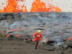 A geologist is collecting sample of molten lava from 2011 Kamoamoa eruption, at Kilauea Volcano, Hawaii, U.S., March 6, 2011. Picture taken on March 6, 2011. Courtesy USGS/Handout via REUTERS