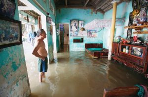 A man stands at his submerged house after heavy rainfall caused by tropical storm Son Tinh at a village outside Hanoi, Vietnam July 24, 2018, REUTERS/Kham