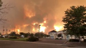 Smoke and flames are seen as a wildfire spreads through Redding, California, the U.S., July 26, 2018, in this still image taken from a video obtained from social media. @pbandjammers/via REUTERS