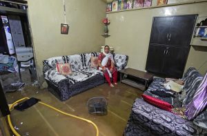 FILE PHOTO: A woman sits inside her flooded house after heavy rains in Ahmedabad, India, June 24, 2018. REUTERS/Amit Dave/File photo
