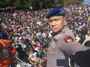 Chief Water Police of Lombok Dewa Wijaya takes a picture in front of hundreds of people attempting to leave the Gili Islands after an earthquake Gili Trawangan, in Lombok, Indonesia, August 6, 2018, in this picture obtained from social media. Indonesia Water Police/Handout/via REUTERS