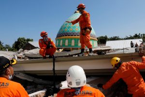 Rescuers and policemen talk on top of a collapsed mosque as they try to find survivors after an earthquake hit on Sunday in Pemenang, Lombok Island, Indonesia, August 7, 2018. REUTERS/Beawiharta