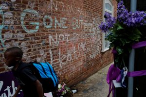 A boy passes tributes written at the site where Heather Heyer was killed during the 2017 white-nationalist rally in Charlottesville, Virginia, U.S., August 1, 2018. REUTERS/Brian Snyder
