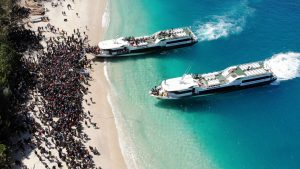 Boats arrive at shore to evacuate people on the island of Gili Trawangan, Lombok, Indonesia, August 6, 2018, in this still image taken from a drone video obtained from social media. Melissa Delport/@trufflejournal/via REUTERS