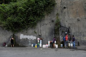 People fill containers with water coming from a mountain, in a road at Plan de Manzano slum in Caracas, Venezuela July 20, 2018. Picture taken July 20, 2018. REUTERS/Marco Bell