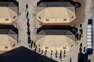 FILE PHOTO: Immigrant children are led by staff in single file between tents at a detention facility next to the Mexican border in Tornillo, Texas, U.S., June 18, 2018. Picture taken June 18, 2018. REUTERS/Mike Blake/File Photo