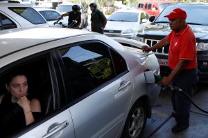 A gas station worker pumps gas into a car at a gas station of the Venezuelan state-owned oil company PDVSA in Caracas, Venezuela August 17, 2018. REUTERS/Marco Bello