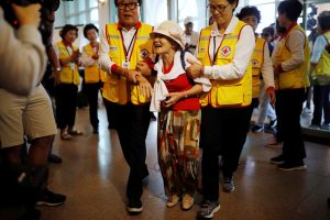 Lee Geum-seom, who has been selected as a participant for a reunion, is helped by volunteers as she arrives at a hotel used as a waiting place in Sokcho, South Korea, August 19, 2018. REUTERS/Kim Hong-Ji