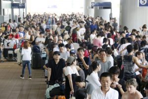 Passengers stranded at Kansai International Airport due to powerful typhoon Jebi queue outside the airport as they wait for the arrival of a special bus service to transport them out of the area, in Izumisato, western Japan, in this photo taken by Kyodo September 5, 2018. Kyodo/via REUTERS
