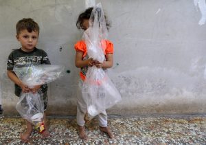 Children hold plastic bags with a paper cup in them, in Idlib, Syria September 3, 2018. REUTERS/Khalil Ashawi