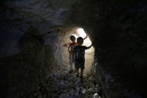 Children walk in a makeshift shelter in an underground cave in Idlib, Syria September 3, 2018. REUTERS/Khalil Ashawi