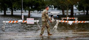 An Army member walks near the flooded Union Point Park Complex as the Hurricane Florence comes ashore in New Bern, North Carolina, U.S., September 13, 2018. REUTERS/Eduardo Munoz