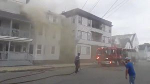 A fire engine is seen near a building emitting smoke after explosions in Lawrence, Massachusetts, United States in this September 13, 2018 still image from social media video footage by Boston Sparks. Boston Sparks/Social Media/via REUTERS
