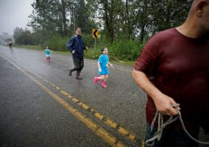 Ember Kelly (C), 5 years old, runs with Iva Williamson (2nd L), 4 years old, to a boat brought up to the edge of flood waters on a street in their neighborhood, during their rescue from rising flood waters in the aftermath of Hurricane Florence in Leland, North Carolina, U.S., September 16, 2018. REUTERS/Jonathan Drake