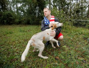 Volunteer rescuer Ryan Nichols of Longview, Texas, pets one of the dogs that were left caged by an owner who fled rising floodwater in the aftermath of Hurricane Florence in Leland, North Carolina, U.S., September 16, 2018. REUTERS/Jonathan Drake