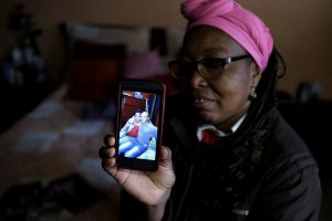 Lina, who said she was raped by dozens of right-wing paramilitary fighters in the Montes de Maria region during the five-decade civil war, shows the picture of her son Over on the mobile phone inside her house in Soacha, on the outskirts of Bogota, Colombia, May 28, 2018. . REUTERS/Nacho Doce