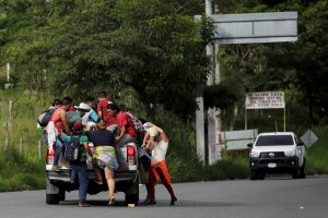 Honduran migrants, part of a caravan trying to reach the U.S., board a truck during a new leg of their travel in Esquipulas, Guatemala October 16, 2018. REUTERS/Jorge Cabrera