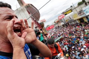 A Honduran migrant, part of a caravan trying to reach the U.S., yells as others wait to cross into Mexico, in Tecun Uman, Guatemala October 19, 2018. REUTERS/Ueslei Marcelino