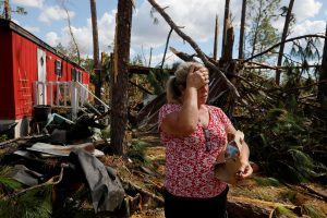 Hurricane Michael survivor Yvette Beasley stands in her front yard during a wellbeing check by a 50 Star Search and Rescue team in Fountain, Florida, U.S., October 17, 2018. REUTERS/Brian Snyder