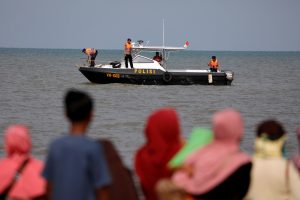 People watch rescue team members on a boat before they head to the Lion Air, flight JT610, sea crash location in the north coast of Karawang regency, West Java province, Indonesia, October 29, 2018. REUTERS/Beawiharta