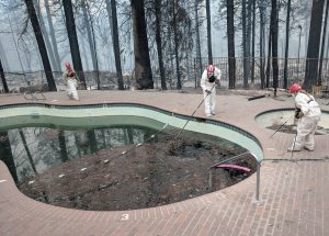 Forensic investigators search a community swimming pool for victims of the Camp Fire in Paradise, California, U.S., November 13, 2018. REUTERS/Noel Randewich