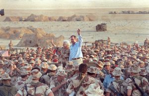 FILE PHOTO: U.S. President George H. W. Bush waves goodbye to U.S. Marines and members of the British 7th Armoured Brigade as they conclude a Thanksgiving Day visit with troops in the Saudi desert November 22, 1990. REUTERS/Rick Wilking/File Photo